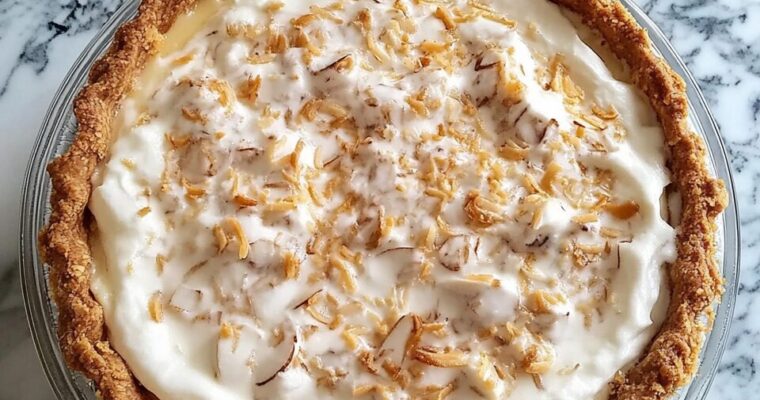 Homemade coconut cream pie with a golden crust and toasted coconut